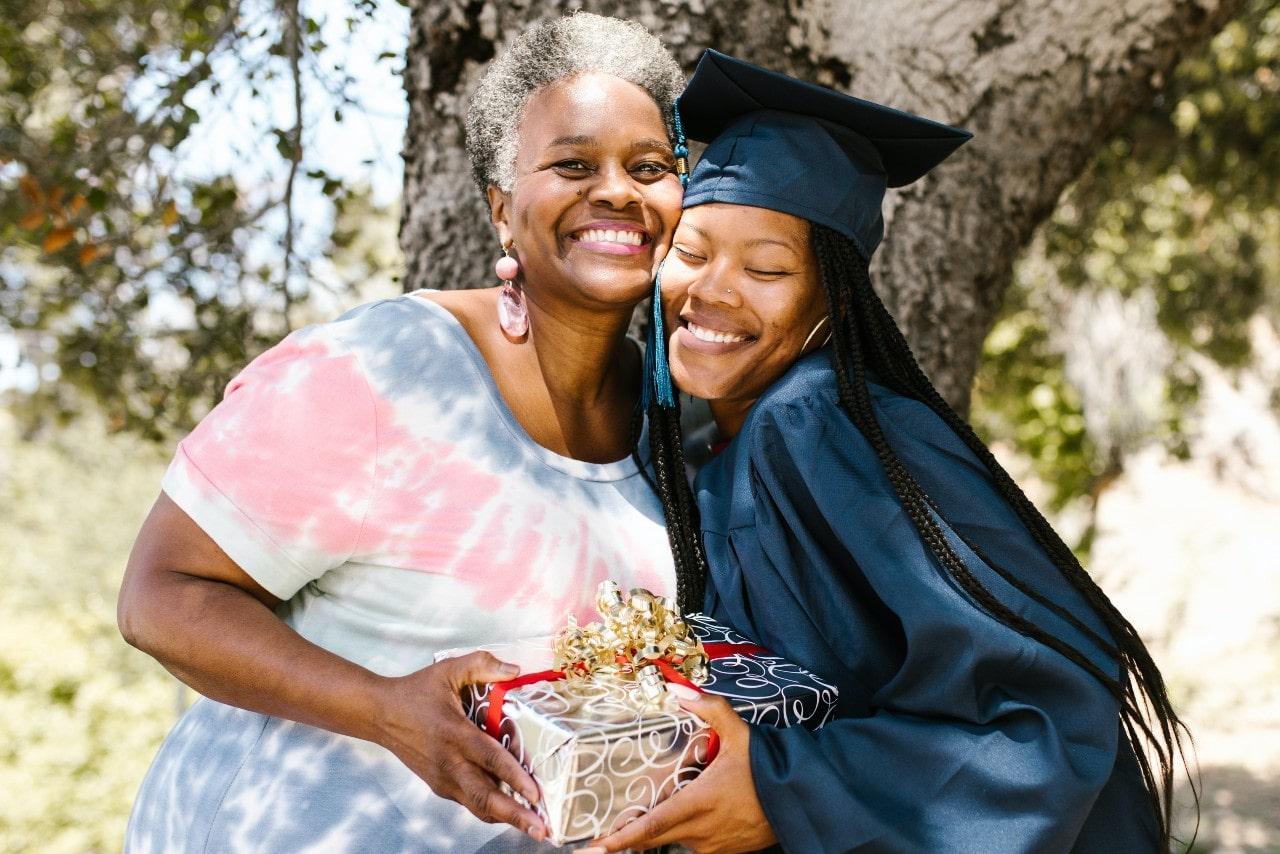 A graduate hugs her grandma to show appreciation for her graduation gift