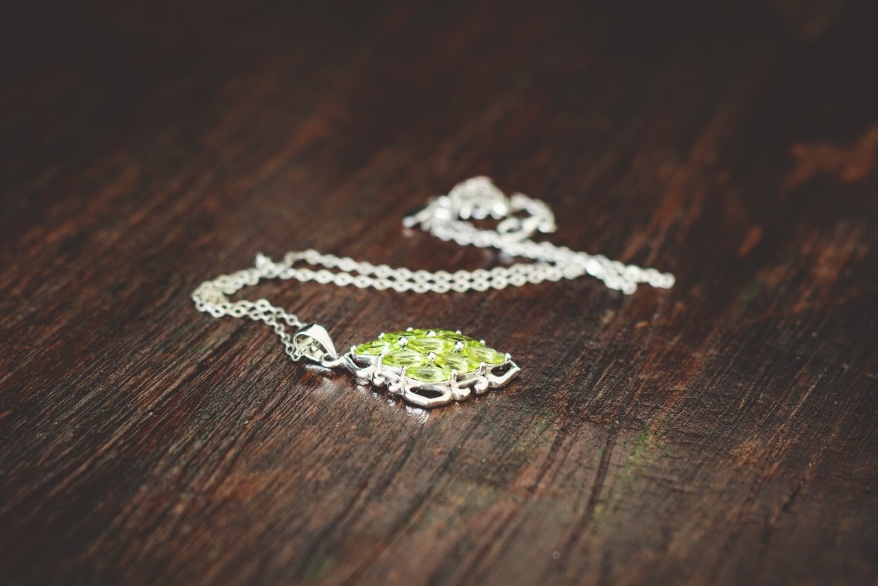 Peridot and sterling silver necklace sitting on a table