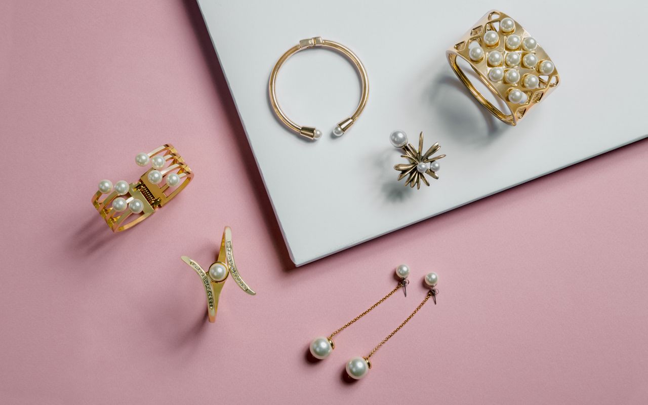 Various pearl jewelry on a pink table