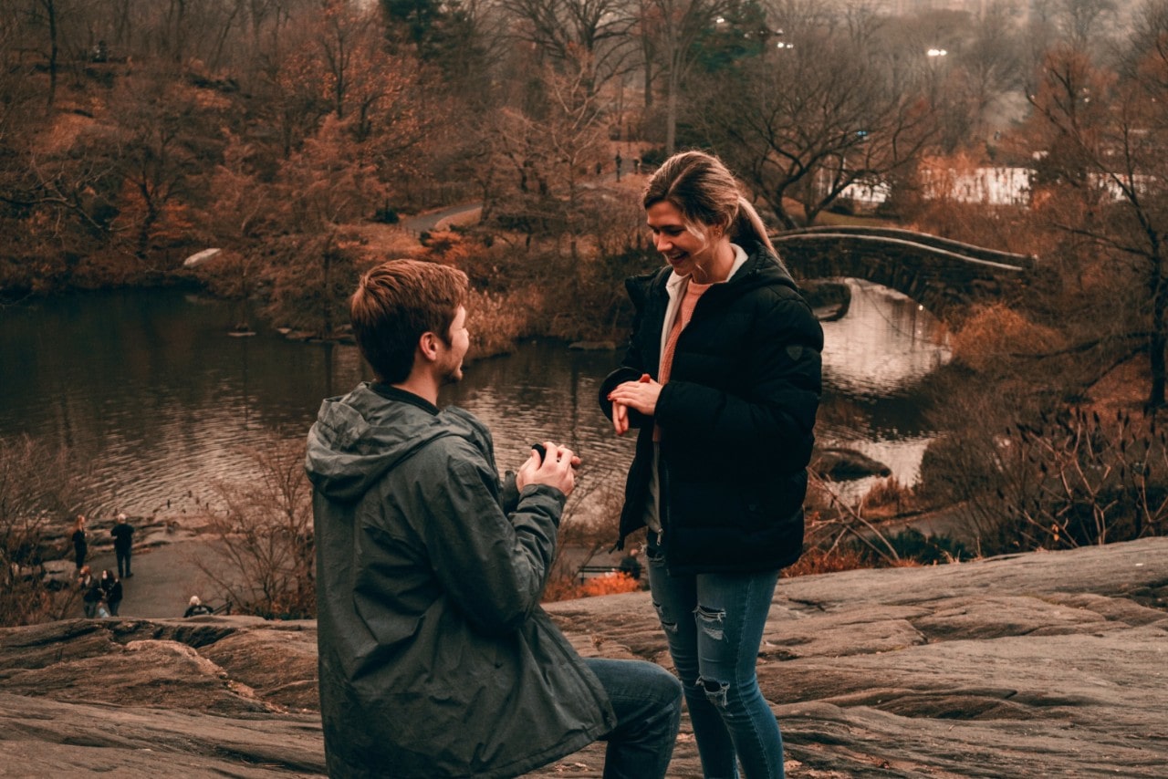 A man proposing to his partner in a picturesque autumn park.