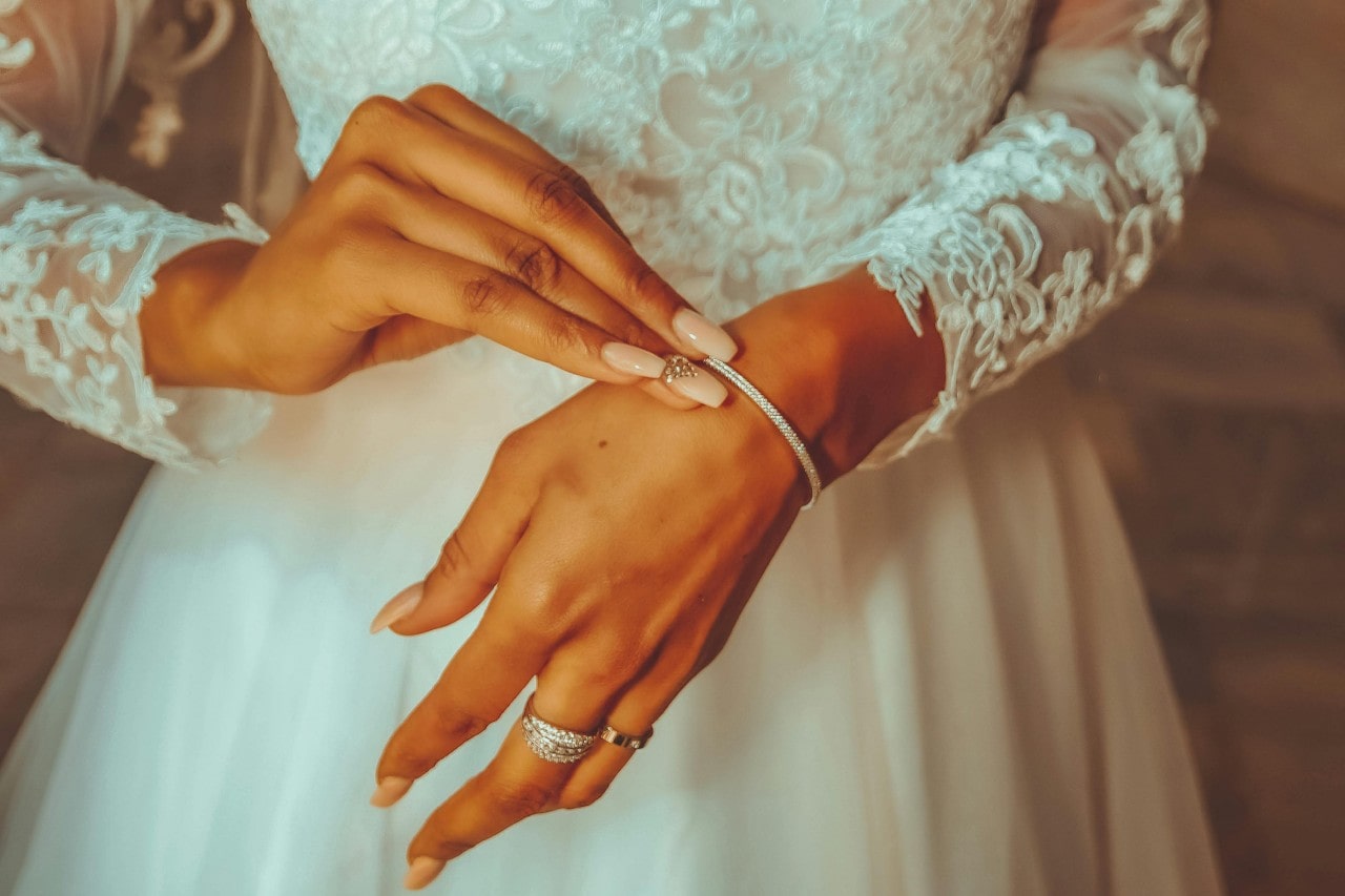 A bride fixing the clasp on her diamond bracelet