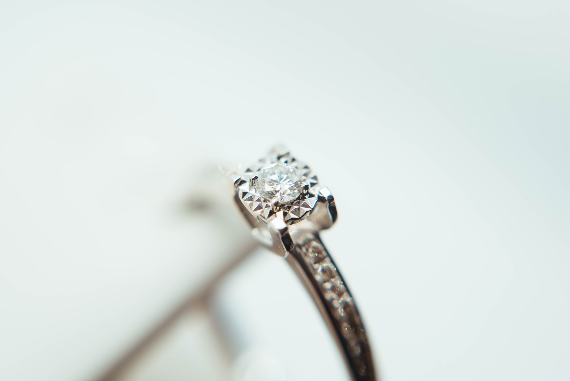 a white gold engagement ring featuring channel set side stones