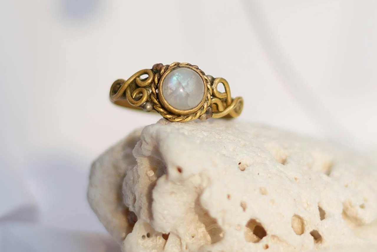 A yellow gold vintage ring with an opal stone atop a white stone.