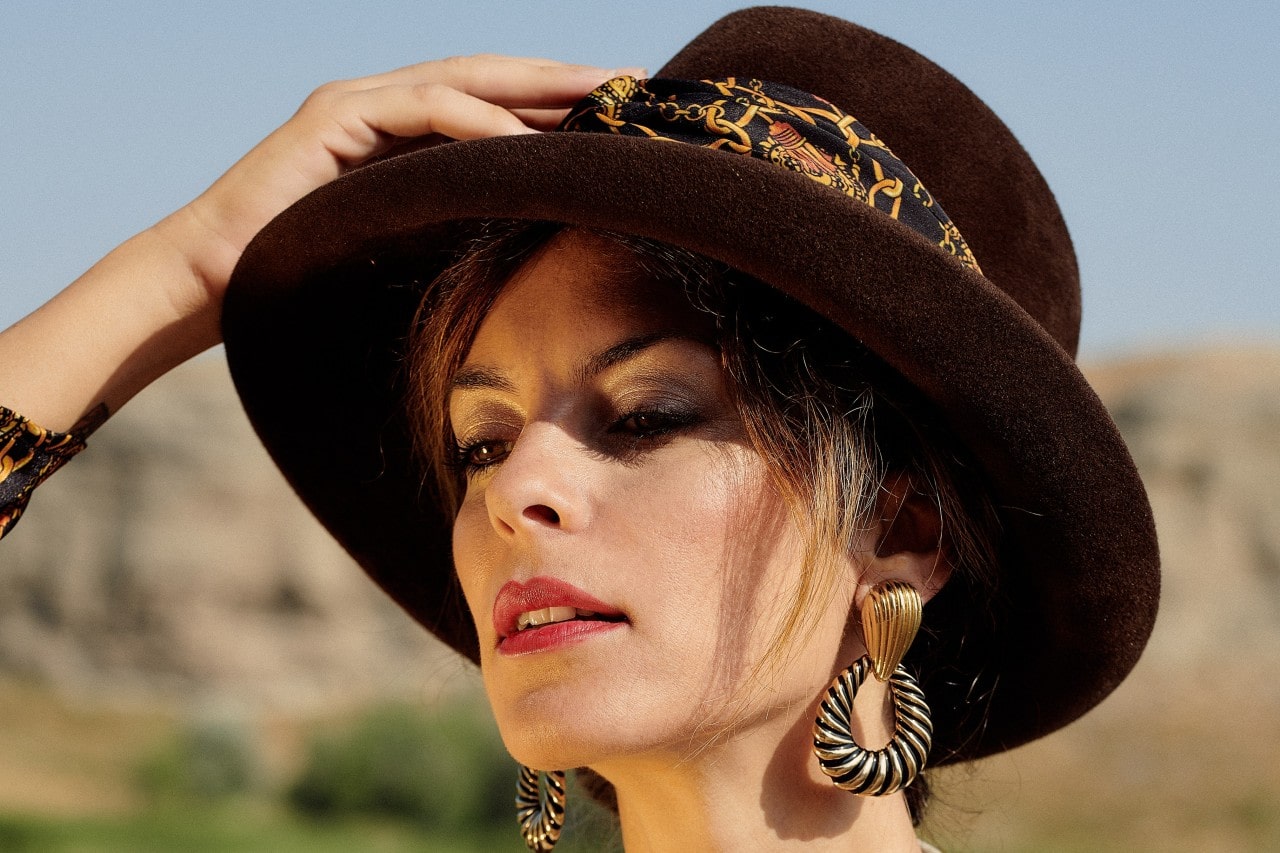 A close-up of a fashionable woman wearing distinctive earrings. 